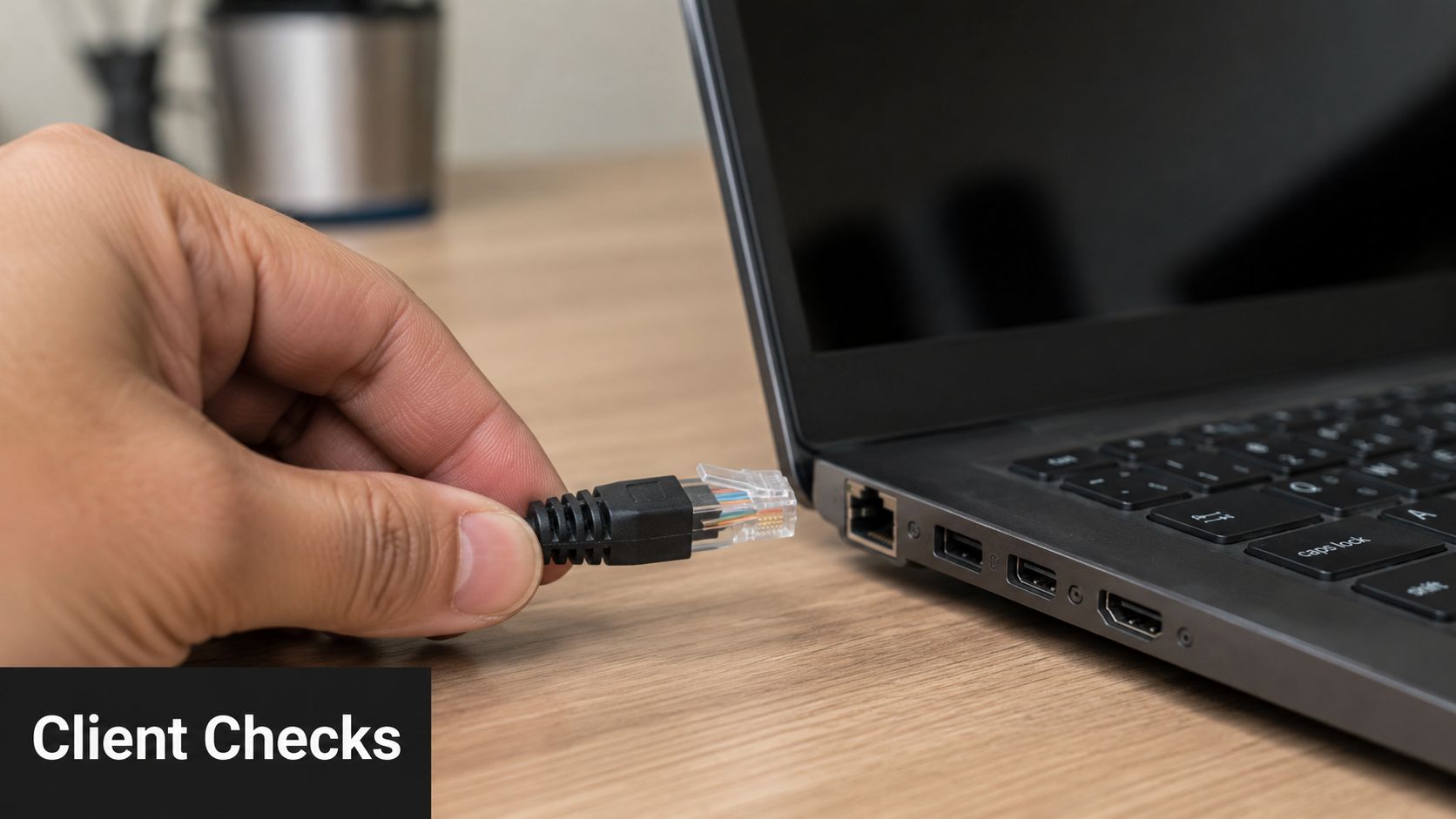 A close-up view of a person hand connecting an ethernet cable to a laptop computer port.